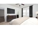 The main bedroom boasts carpet, a ceiling fan, a dresser, and windows with coverings at 3523 Evening Star Dr, Winter Haven, FL 33881