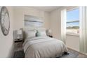Cozy main bedroom with soft bedding, neutral tones, and a large window for natural light at 398 Eventide Ave, Mascotte, FL 34753