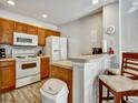 Well-lit kitchen with white appliances and cozy breakfast bar seating for two at 4560 Spigold Court, Kissimmee, FL 34746