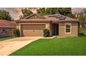 Inviting single-story home with a well-manicured lawn, two car garage, and cozy covered entrance at 543 Nardello Dr, Deltona, FL 32725