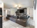 A spacious living room features a large gray sectional sofa, a ceiling fan, and tile flooring at 543 Nardello Dr, Deltona, FL 32725