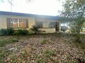 Single story home with neutral tone and front lawn covered with leaves at 628 Cardinal St, Ocoee, FL 34761