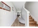 Bright hallway featuring wood-look flooring, neutral paint, and stairs at 725 Cresting Oak Cir # 117, Orlando, FL 32824