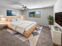 A cozy bedroom featuring a ceiling fan, neutral color scheme, and a large window for natural light at 9345 Buttonwood St, Orlando, FL 32825