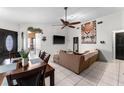 Bright living room with tile floors, a modern ceiling fan, and an open layout at 9911 Dean Cove Ln, Orlando, FL 32825