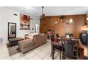 Open-concept living room with tile flooring, ceiling fan, and neutral decor at 9911 Dean Cove Ln, Orlando, FL 32825