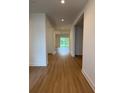 Bright hallway with wood-look floors, recessed lighting, and an open floor plan leading to the backyard at 1059 Gloryland Ct, Sanford, FL 32771
