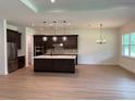 A spacious kitchen featuring stainless steel appliances, dark cabinetry, and an island with a white countertop at 1059 Gloryland Ct, Sanford, FL 32771