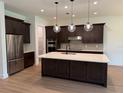 A spacious kitchen featuring stainless steel appliances, dark cabinetry, and an island with a white countertop at 1059 Gloryland Ct, Sanford, FL 32771