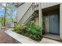 Exterior view showing a light gray home featuring a welcoming front door with lush landscaping at 111 Crown Oaks Way # 101, Longwood, FL 32779