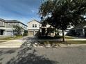 Inviting two-story home with a paved driveway, neat landscaping, and a cozy front porch in a residential neighborhood at 11456 Short Story St, Orlando, FL 32832