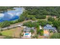 Aerial view of a luxury home with a pool surrounded by lush landscaping near a lake at 1415 Brumley Rd, Chuluota, FL 32766