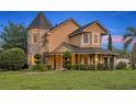 Charming home exterior featuring a covered porch, manicured landscaping, and unique architectural details at 1415 Brumley Rd, Chuluota, FL 32766