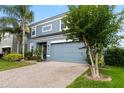 Beautiful two-story house with a brick-paved driveway, a well-manicured lawn, and colorful shrubs at 15210 Montesino Dr, Orlando, FL 32828