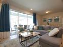 Open-concept living room with sliding glass doors to the screened patio offers lots of natural light at 197 Jetty Way, Davenport, FL 33897