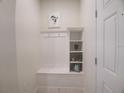 Mudroom with built-in bench, shelving, and coat hooks provides an organized entryway at 197 Jetty Way, Davenport, FL 33897