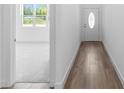 Bright entryway featuring wood-look flooring, a white door, and an open view into a carpeted room at 2065 East Pkwy, Deland, FL 32724