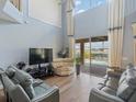 Bright living room with high ceilings, a ceiling fan, and sliding glass doors leading to the pool area at 2803 Boating Blvd, Kissimmee, FL 34746