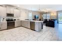Bright, open kitchen with stainless steel appliances, tiled floor, and island at 303 Ocean Course Ave, Davenport, FL 33896