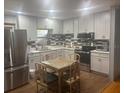 Modern kitchen features white cabinets, stainless steel appliances, and stylish backsplash at 404 E Kentucky Ave, Deland, FL 32724