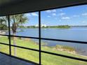 Screened porch view overlooking the lake and the blue sky with a palm tree to the left at 4109 Fairview Vista Pt # 315, Orlando, FL 32804