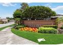 Inviting community entrance with a brick sign, lush greenery, and colorful flowers creating a welcoming atmosphere at 453 Kays Landing Dr, Sanford, FL 32771