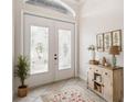 Bright foyer with decorative double doors, a charming table display, and a stylish rug on tile flooring at 453 Kays Landing Dr, Sanford, FL 32771