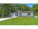 Beautifully updated single-story home with fresh paint, landscaping, and spacious front yard at 50 Community Dr, Debary, FL 32713