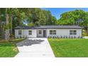 Charming single-story home featuring a well-manicured lawn, modern paint, and a spacious driveway at 50 Community Dr, Debary, FL 32713