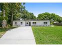Inviting single-story home with a long driveway, beautiful lawn and fresh exterior paint at 50 Community Dr, Debary, FL 32713