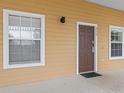 Charming home exterior featuring a brown front door, light beige siding, and white trim at 510 Rum Run # 33 510, Davenport, FL 33837