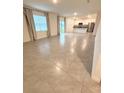 Bright and spacious living room with tiled floors, flowing seamlessly into the kitchen at 5168 Greenheart Ave, Mount Dora, FL 32757