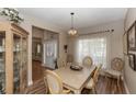 Formal dining room with wood flooring, a chandelier, and large windows draped in sheer curtains at 603 Yorkshire Dr, Oviedo, FL 32765