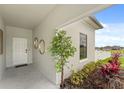 Inviting covered entry features a white front door, decorative plants, and stylish decor accents at 6454 Chorus Dr, Mascotte, FL 34753