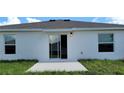 Clean back exterior with sliding glass doors that open to a spacious concrete patio at 707 Staffora St, Haines City, FL 33844