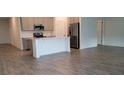 Modern kitchen featuring an island, stainless steel appliances, and stylish wood-look floors at 707 Staffora St, Haines City, FL 33844