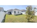 Spacious backyard featuring a lush green lawn, surrounded by a white vinyl fence at 853 Bocavista Ct, Davenport, FL 33896