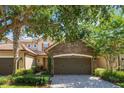 Attractive townhome featuring stone accents, a two-car garage, and mature landscaping at 10533 Belfry Cir, Orlando, FL 32832