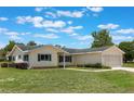 Well-kept single-story home with a green lawn and attached two-car garage, with windows and shrubbery at 10980 Sw 62Nd Ave, Ocala, FL 34476