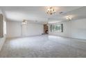 Spacious living room with plush carpeting, brick fireplace, ceiling fans, and bright natural light at 10980 Sw 62Nd Ave, Ocala, FL 34476