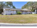 Lovely home featuring a green front lawn, sidewalk, and mature trees at 1101 Mizell Rd, Leesburg, FL 34748