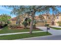 Two-story home boasts manicured lawn, mature trees, and a brick driveway to the attached two-car garage at 11556 Via Lucerna Cir, Windermere, FL 34786