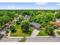 An aerial view shows the home's position on a grassy lot and many mature trees surrounding the property at 1632 Oriole Ave, Orlando, FL 32803
