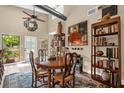 Light-filled dining room with high ceilings, unique artwork, and a rustic wooden table complemented by matching chairs at 1632 Oriole Ave, Orlando, FL 32803