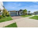 Attractive home with a brick driveway, manicured lawn, and mature trees under a bright blue sky, showcasing curb appeal at 1757 Standing Rock Cir, Oakland, FL 34787