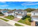 A two-story home featuring solar panels, a brick driveway, and well-maintained landscaping at 178 Aria Way, Davenport, FL 33837