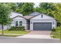 Charming single-Gathering home featuring a two-car garage, stone accents, and professionally landscaped front yard at 2159 Marsh Sedge Ln, Winter Park, FL 32792