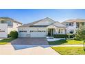 Beautiful single-Gathering home featuring a well-kept lawn, brick driveway, and attached three-car garage at 2417 Annacella Ave, Kissimmee, FL 34741