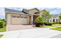 Charming house with brick paved driveway, a two-car garage, and a blue front door at 2604 Meadowedge Loop, St Cloud, FL 34772