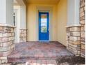 Inviting front porch featuring brick columns and steps, leading to a bright blue front door at 2604 Meadowedge Loop, St Cloud, FL 34772